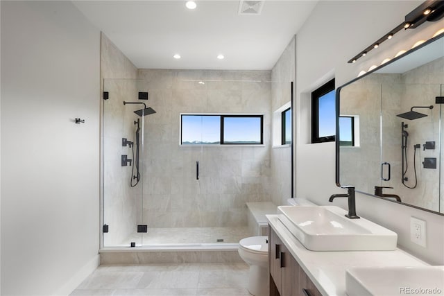 bathroom featuring walk in shower, vanity, a healthy amount of sunlight, and toilet