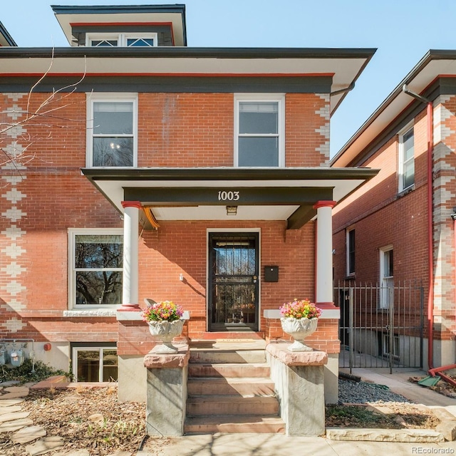 view of front of home with a porch and brick siding