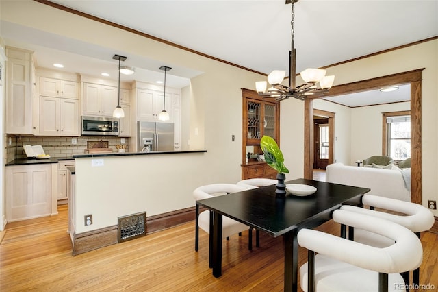 dining area with recessed lighting, visible vents, light wood-style floors, ornamental molding, and a chandelier