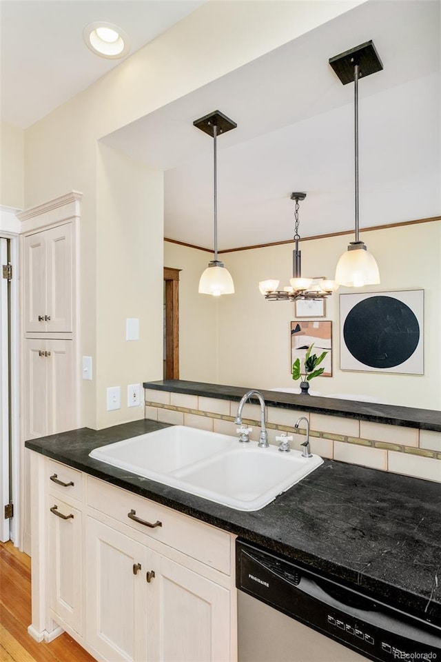 kitchen featuring a sink, light wood-type flooring, backsplash, dishwasher, and decorative light fixtures