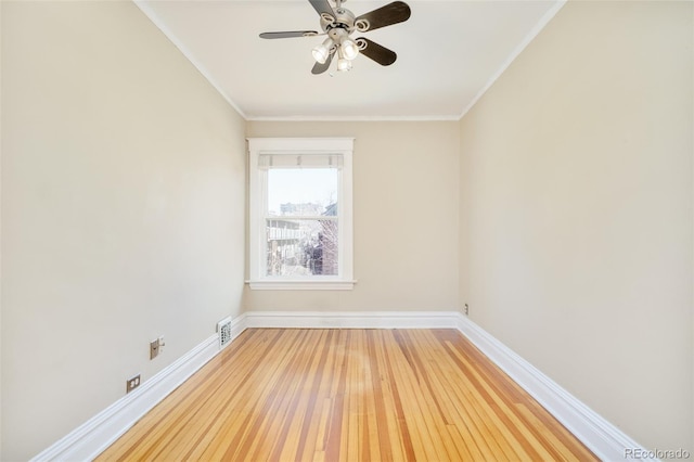 unfurnished room featuring ornamental molding, light wood-type flooring, visible vents, and baseboards