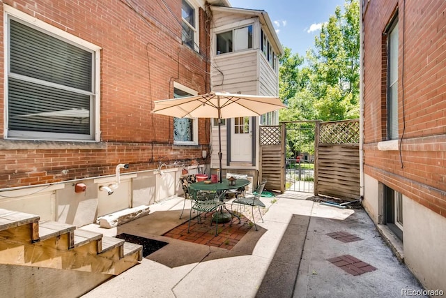 view of patio / terrace featuring a gate, fence, and outdoor dining area