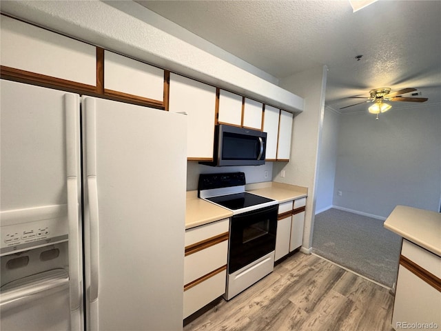 kitchen featuring range with electric stovetop, a textured ceiling, white cabinets, stainless steel microwave, and white fridge with ice dispenser
