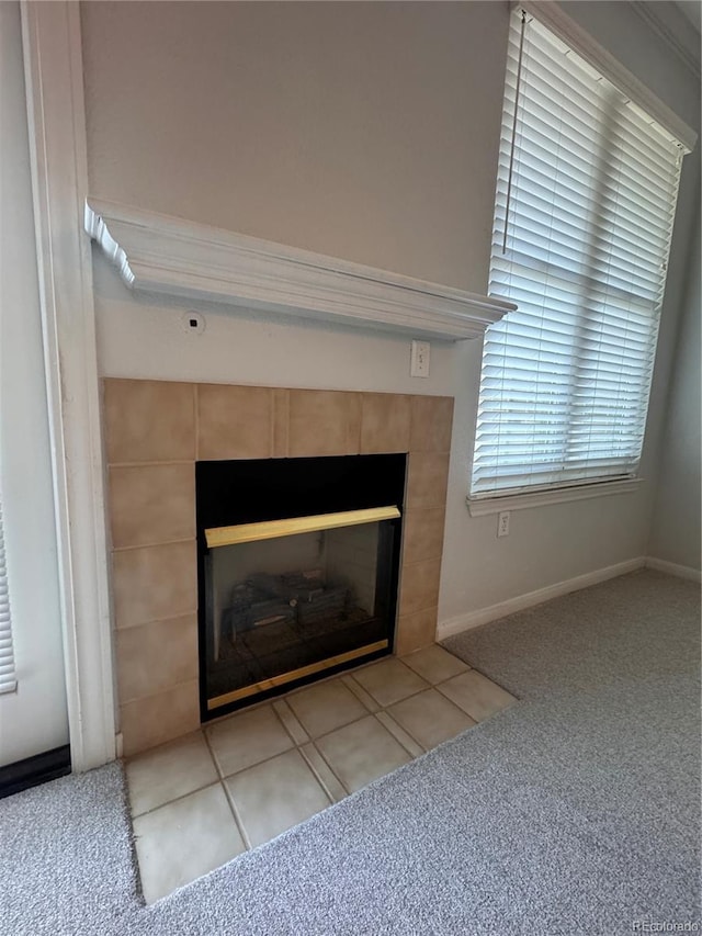 room details with a tiled fireplace, carpet, and baseboards