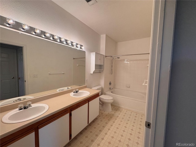 bathroom with double vanity, a sink, tile patterned floors, and toilet