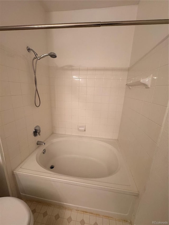 bathroom featuring toilet, tile patterned floors, and washtub / shower combination