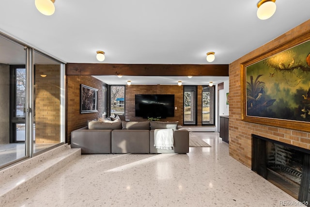 living room with a brick fireplace, a healthy amount of sunlight, and beamed ceiling