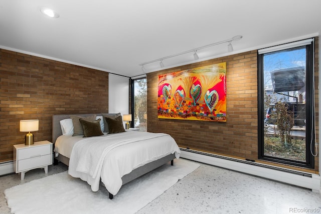 bedroom featuring brick wall and a baseboard heating unit