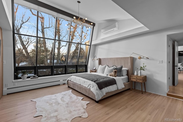 bedroom with a wall unit AC, wood finished floors, a high ceiling, a baseboard heating unit, and a notable chandelier