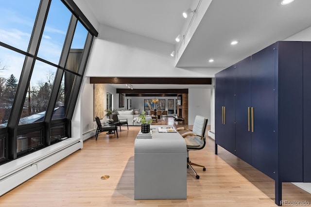 home office featuring a baseboard radiator, light wood-style floors, baseboard heating, and a towering ceiling