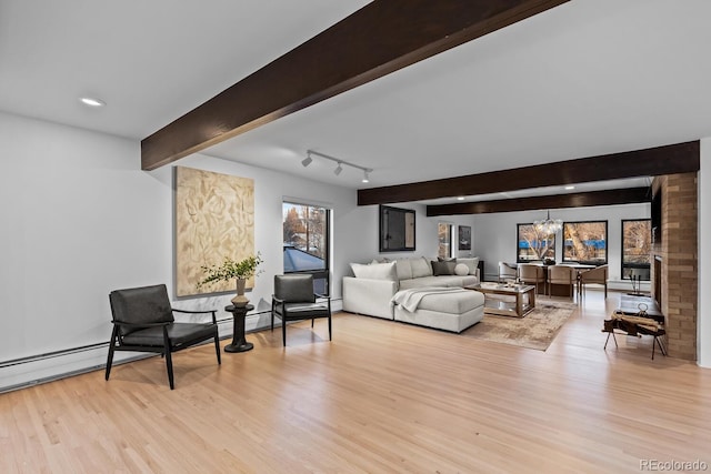 living room featuring a fireplace, beam ceiling, a notable chandelier, and wood finished floors