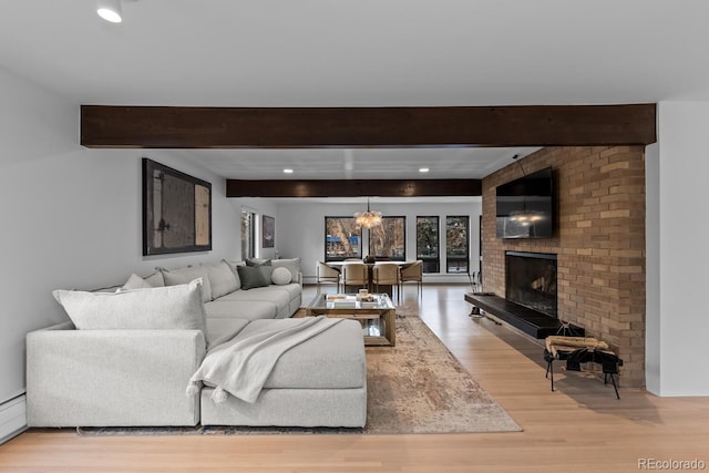 living room with light wood-type flooring, beamed ceiling, recessed lighting, a fireplace, and a baseboard radiator