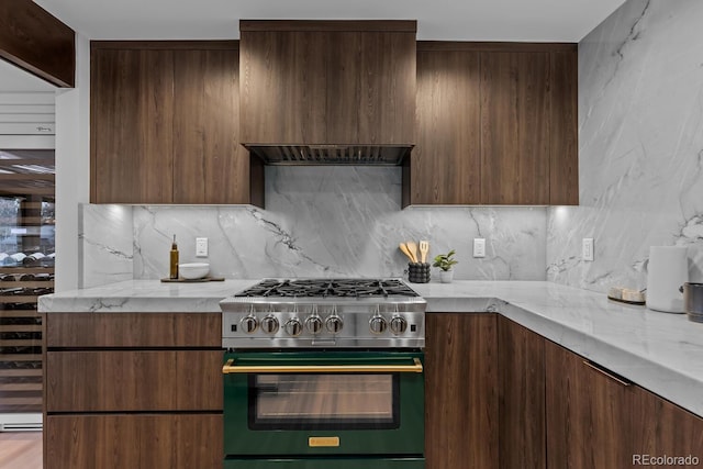 kitchen featuring tasteful backsplash, modern cabinets, high end stainless steel range, and light stone countertops