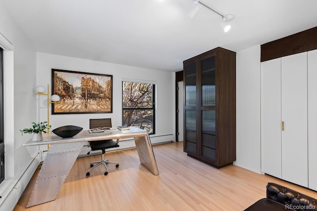 office area with light wood-style floors and baseboard heating