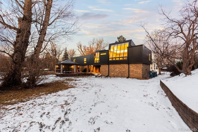 snow covered property with a gazebo and a garage