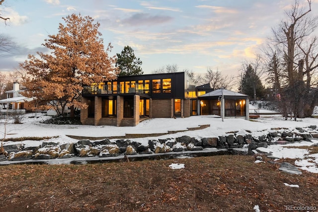 snow covered property with a gazebo and an attached garage