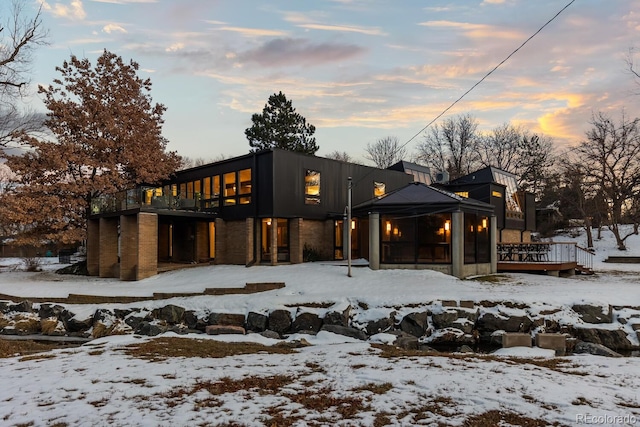 snow covered house featuring a garage