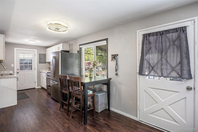 dining room featuring dark wood-type flooring, baseboards, and electric panel