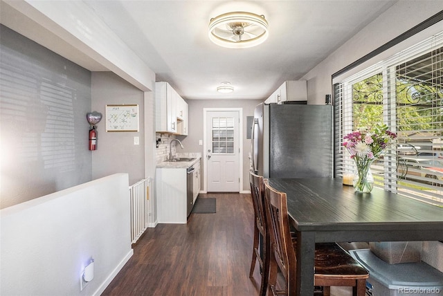 kitchen featuring a sink, dark wood finished floors, appliances with stainless steel finishes, and white cabinetry