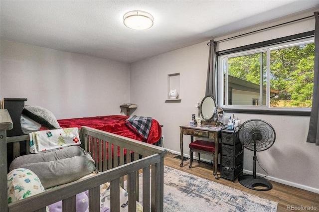 bedroom featuring baseboards and wood finished floors