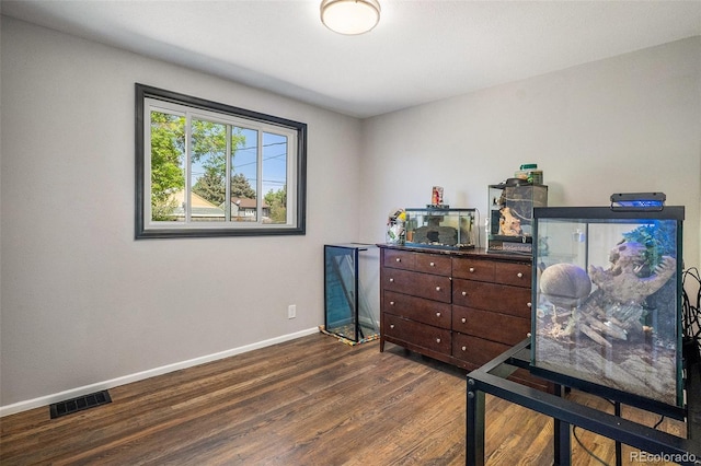 home office with dark wood-type flooring and baseboards