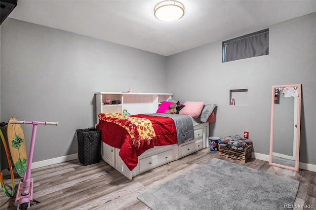 bedroom with wood finished floors and baseboards