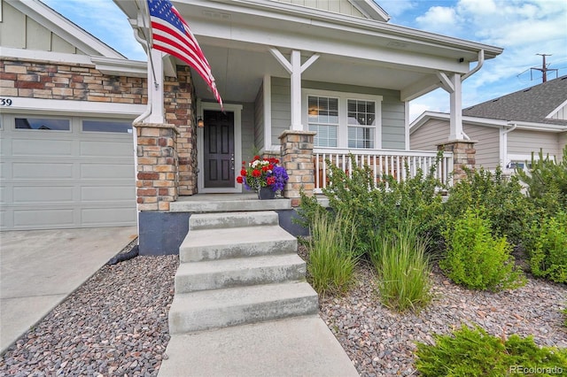 8839 Culebra St, Arvada, CO 80007 - view of exterior entry with board and batten siding, covered porch, stone siding, and a garage
