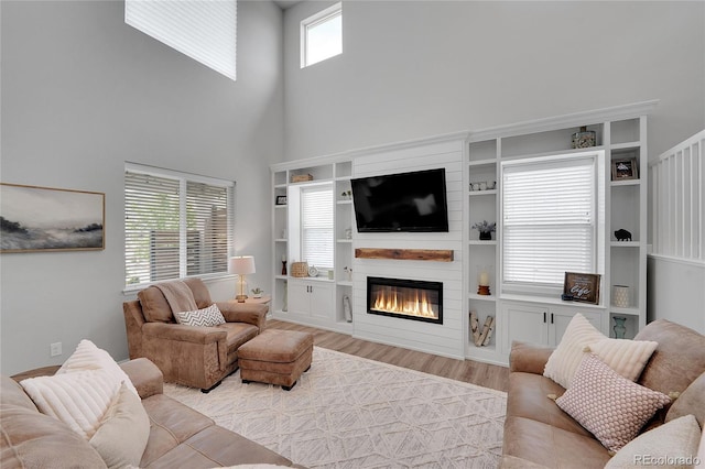 8839 Culebra St, Arvada, CO 80007 - living area featuring a towering ceiling, wood finished floors, and a large fireplace