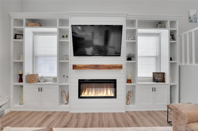 8839 Culebra St, Arvada, CO 80007 - living room featuring light wood-style flooring, a fireplace, and healthy amount of natural light