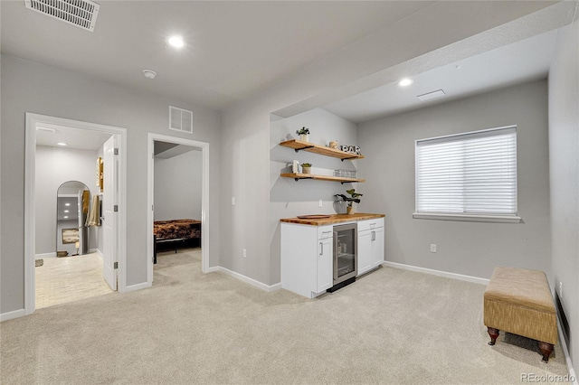 8839 Culebra St, Arvada, CO 80007 - indoor wet bar with beverage cooler, light colored carpet, recessed lighting, and arched walkways