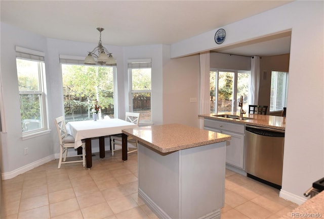 kitchen with a center island, an inviting chandelier, sink, stainless steel dishwasher, and decorative light fixtures