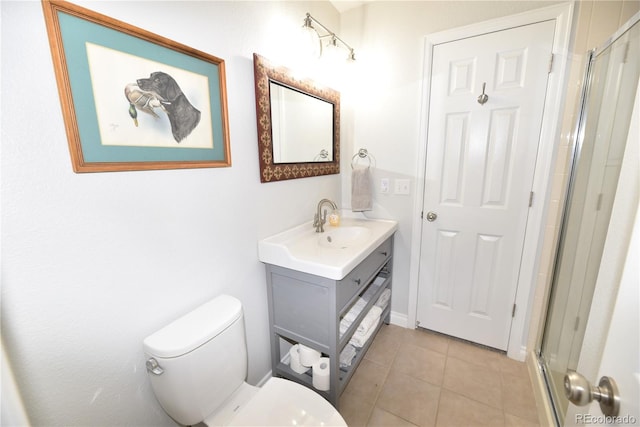 bathroom featuring tile patterned floors, a shower with door, vanity, and toilet