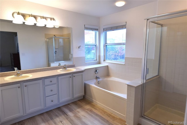 bathroom with separate shower and tub, hardwood / wood-style floors, and vanity