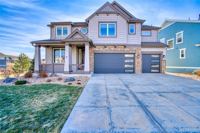 craftsman-style house featuring a front lawn, a porch, and a garage