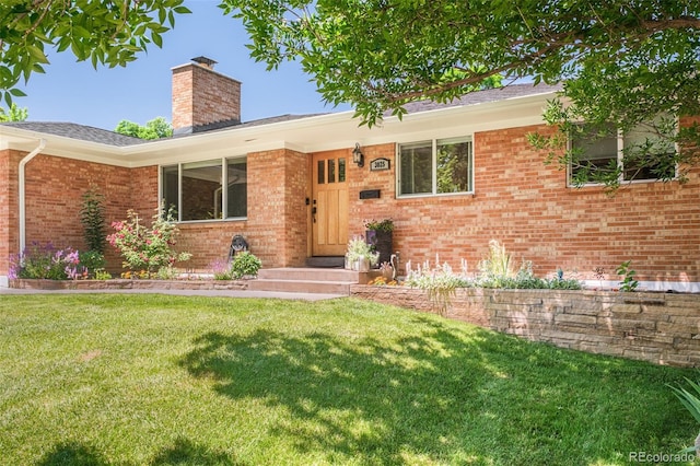 3025 S Norman Ct, Denver, CO 80224 - view of front of house with a chimney, a front lawn, and brick siding