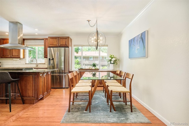 3025 S Norman Ct, Denver, CO 80224 - dining space with crown molding, a chandelier, and light wood-style floors