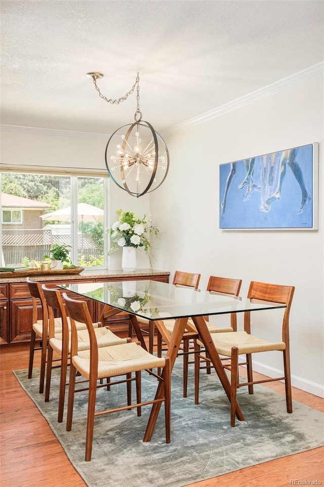 3025 S Norman Ct, Denver, CO 80224 - dining space with a chandelier, light wood finished floors, and crown molding