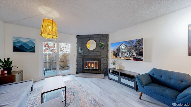 living room featuring hardwood / wood-style floors, a brick fireplace, and a textured ceiling