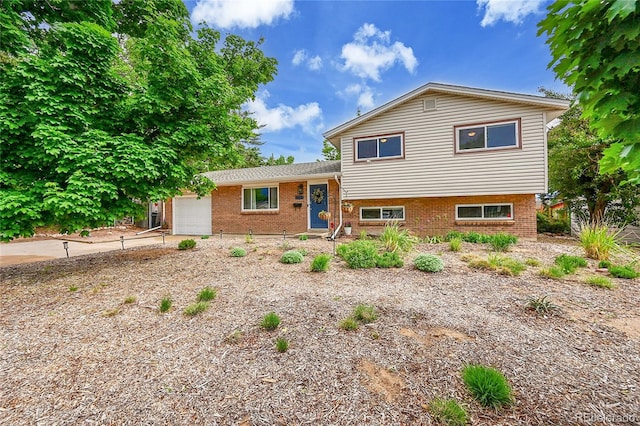 962 S Potomac Way, Aurora, CO 80012 - tri-level home with a garage, brick siding, and concrete driveway