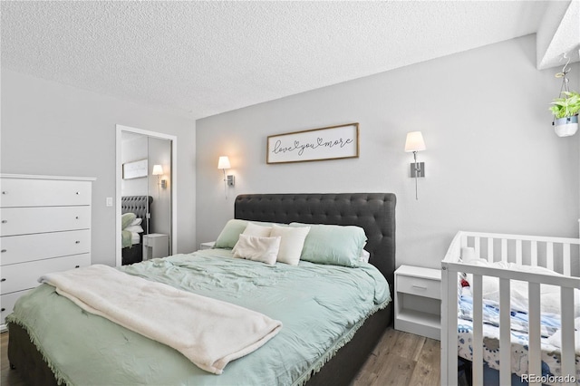 bedroom with wood finished floors and a textured ceiling