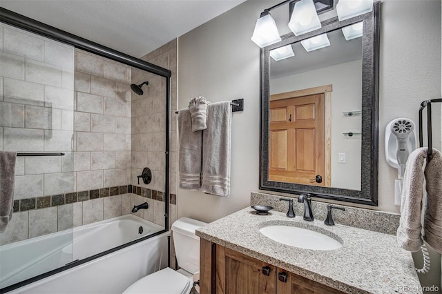 bathroom featuring enclosed tub / shower combo, toilet, and vanity