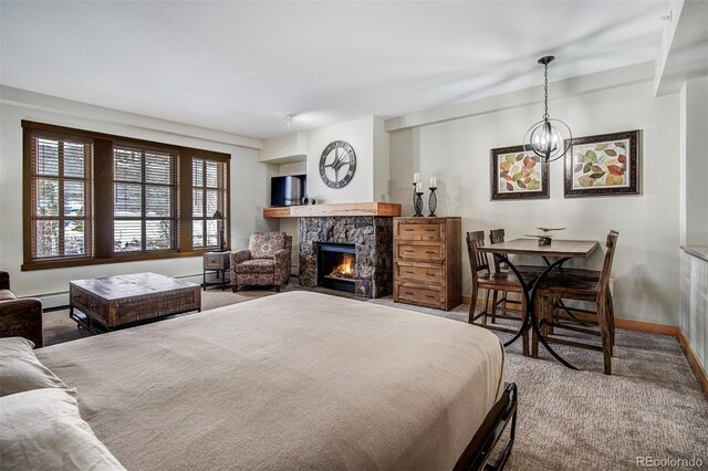 bedroom with a notable chandelier, carpet flooring, a fireplace, and a baseboard radiator