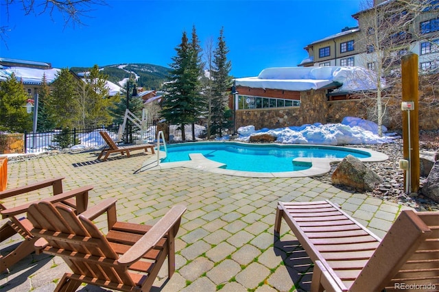 view of pool featuring a mountain view, a patio area, a fenced in pool, and fence