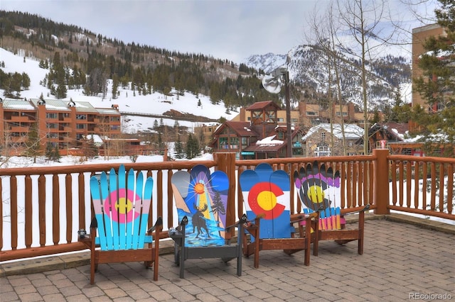 snow covered patio featuring a mountain view