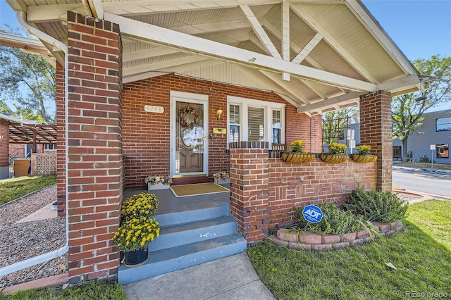 view of exterior entry featuring covered porch