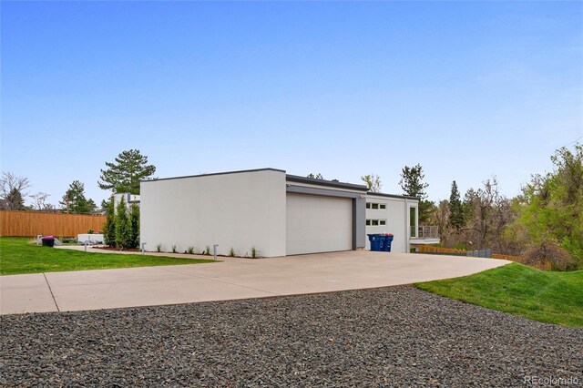 garage featuring fence and concrete driveway