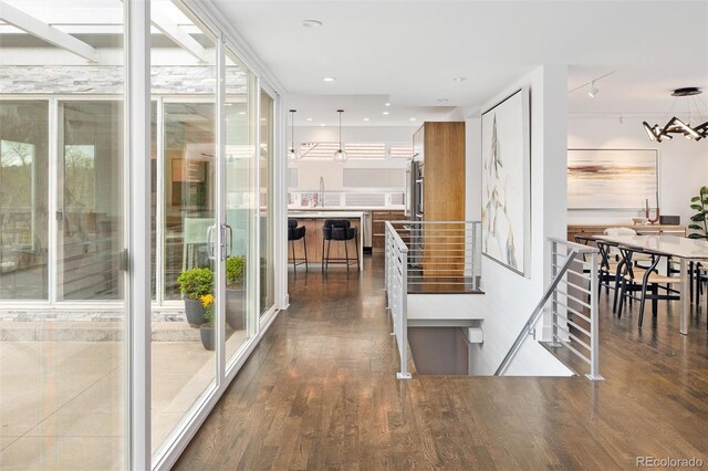 hallway featuring plenty of natural light, a sink, and dark wood finished floors