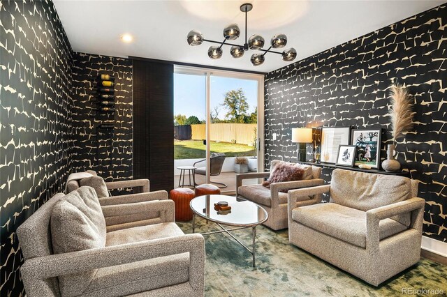 living area with wallpapered walls and a notable chandelier