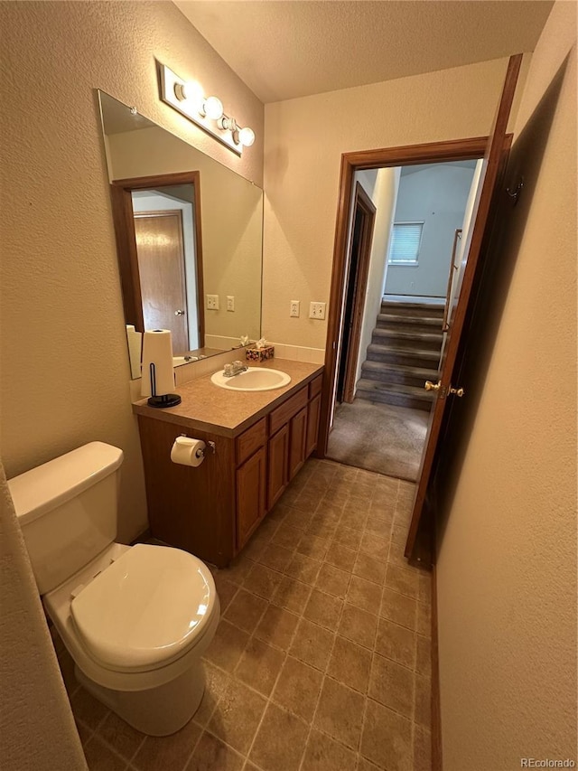 374 Krypton Ct, Loveland, CO 80537 - bathroom with toilet, vanity, a textured ceiling, a textured wall, and tile patterned floors