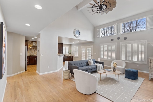 living room featuring light wood-style flooring, plenty of natural light, baseboards, high vaulted ceiling, and beam ceiling